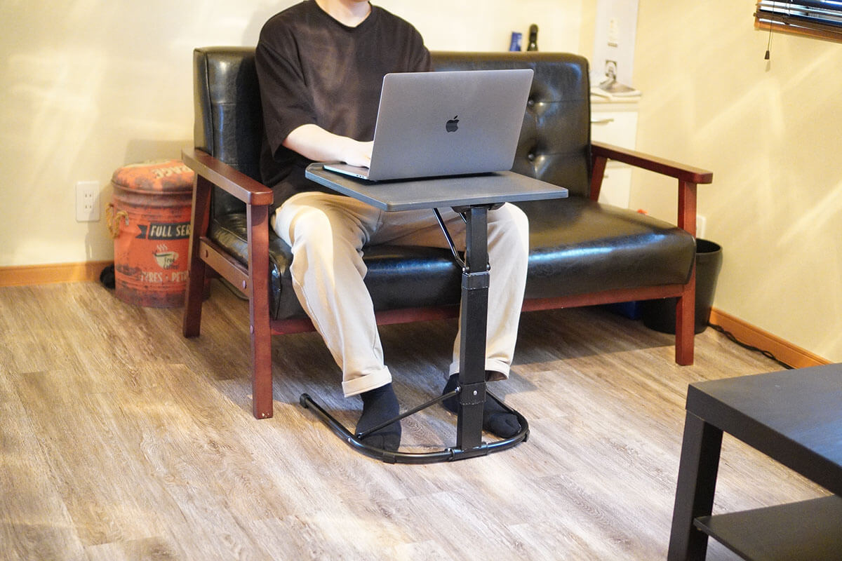 ソファに座ってパソコンをしている男性